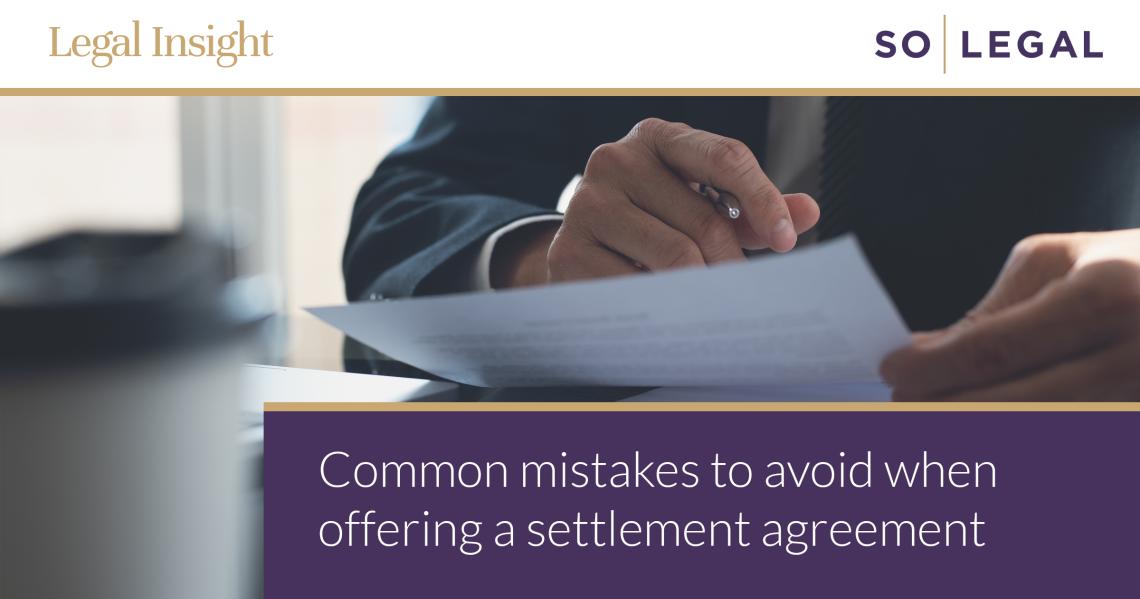 Person reading a settlement agreement document at a desk, representing careful review of employment terms before signing.