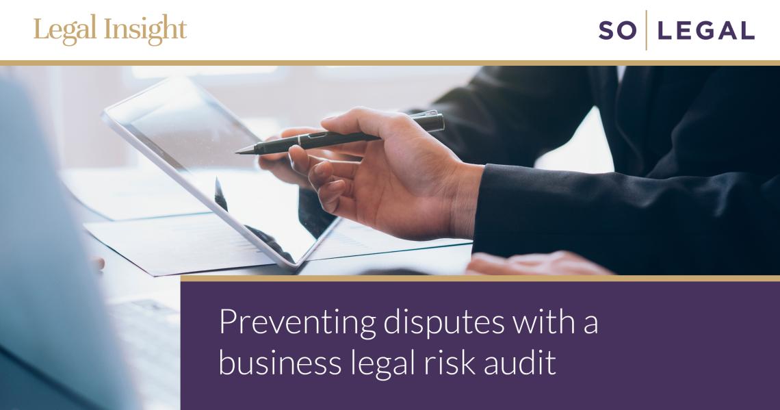 Business owner reviewing contracts as part of a legal risk audit to help prevent disputes.