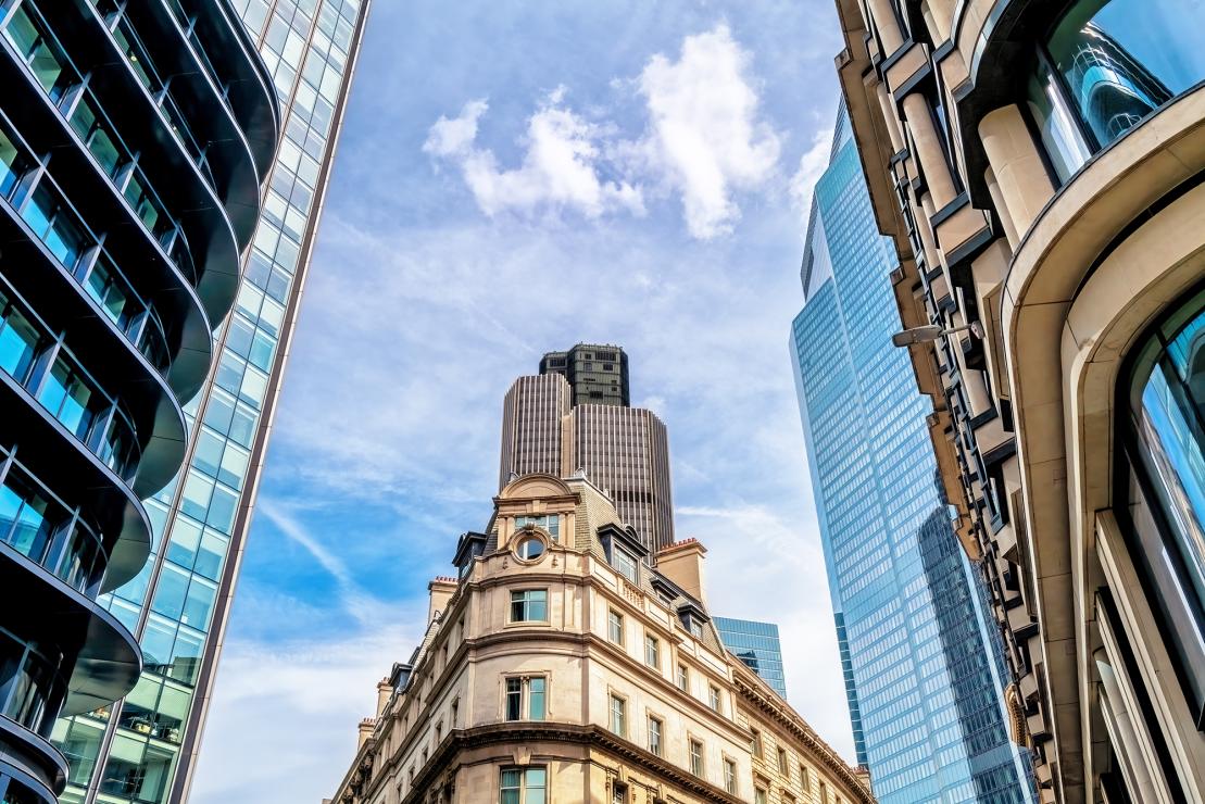 Modern and historic commercial buildings in a city financial district, representing commercial property refinancing and investment